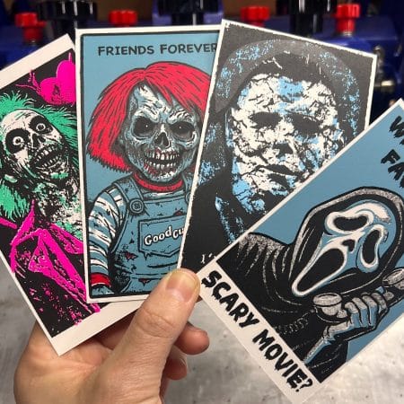 Hand holding four zombie-style classic horror Valentine’s Day cards, each hand screen printed with bold graphic artwork and dark humor messages.