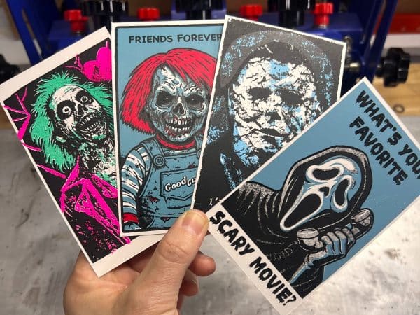 Hand holding four zombie-style classic horror Valentine’s Day cards, each hand screen printed with bold graphic artwork and dark humor messages.