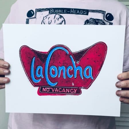 Artist holding a hand-pulled La Concha Motel inspired screen print for scale and detail reference.