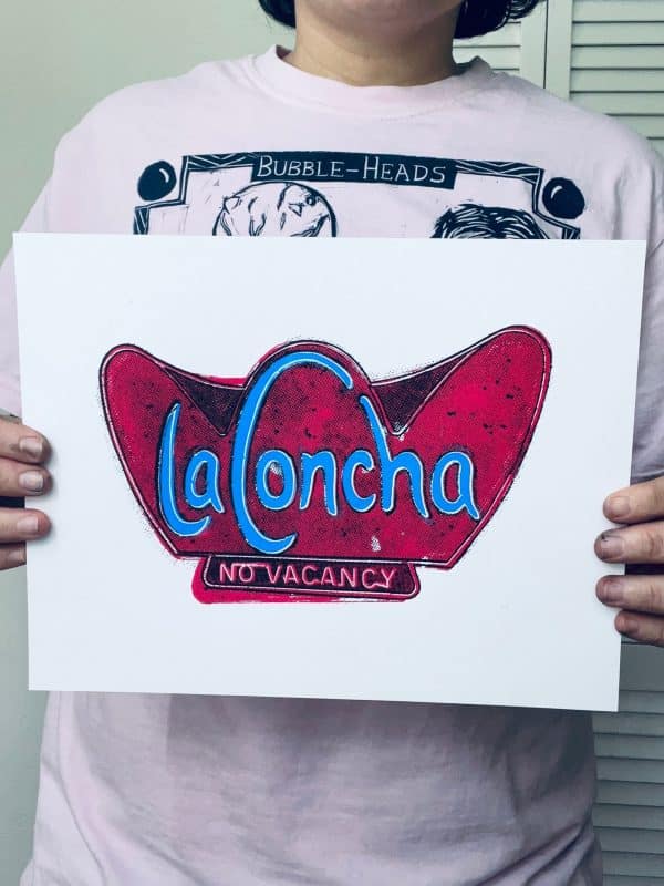 Artist holding a hand-pulled La Concha Motel inspired screen print for scale and detail reference.