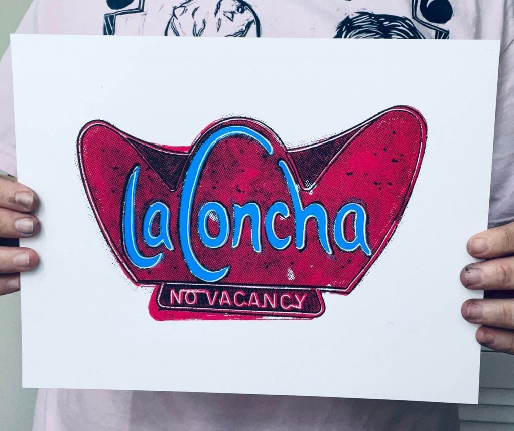 Artist holding a hand-pulled La Concha Motel inspired screen print for scale and detail reference.