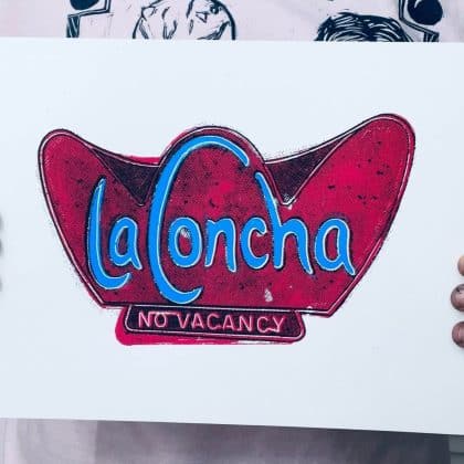 Artist holding a hand-pulled La Concha Motel inspired screen print for scale and detail reference.
