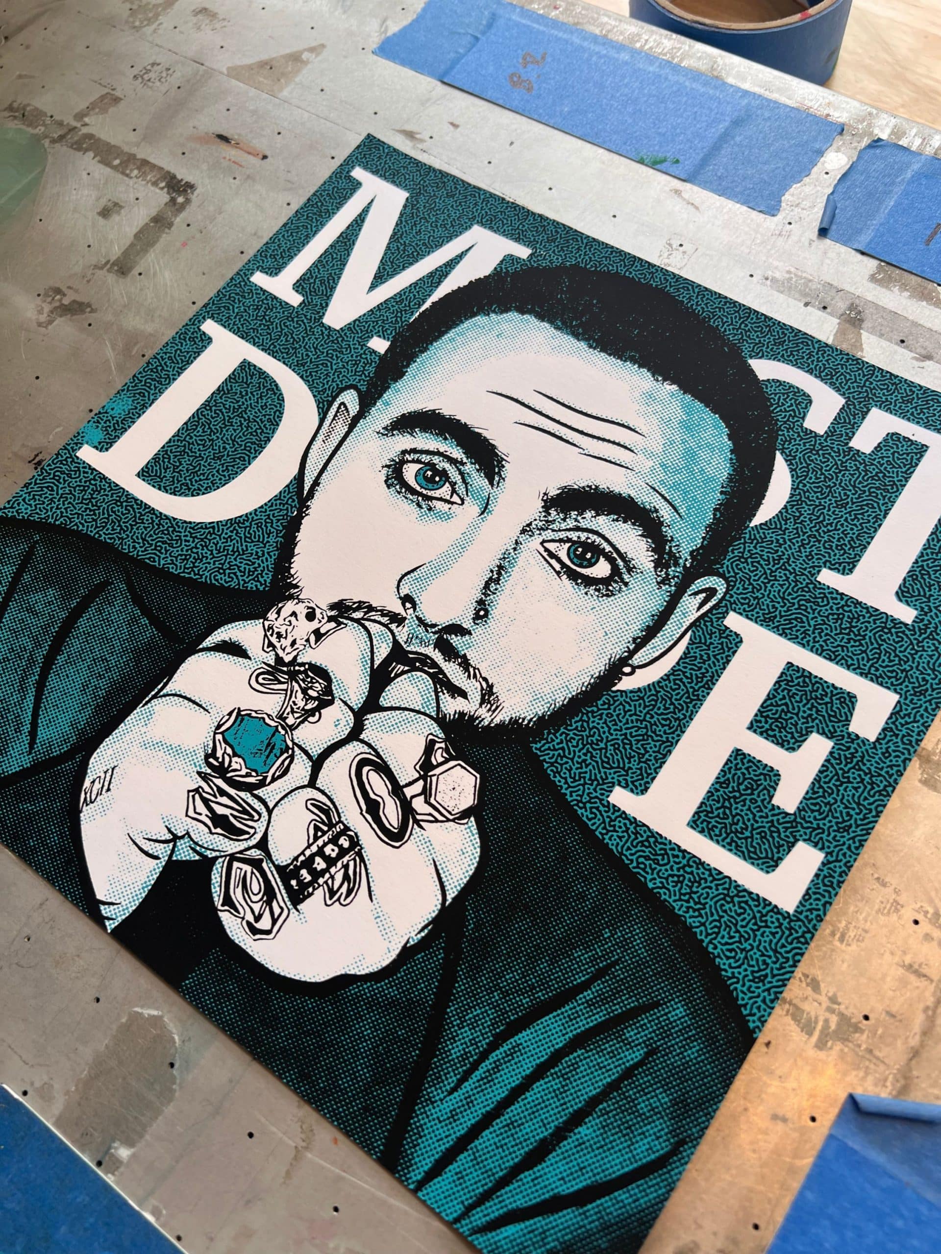 Angled photograph of a Mac Miller inspired portrait screen print featuring bold linework, halftones, and two-color printing.